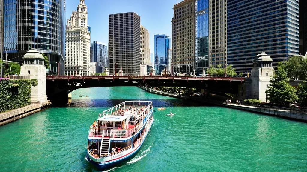 A tour boat on the Chicago River between the downtown towers on a clear day