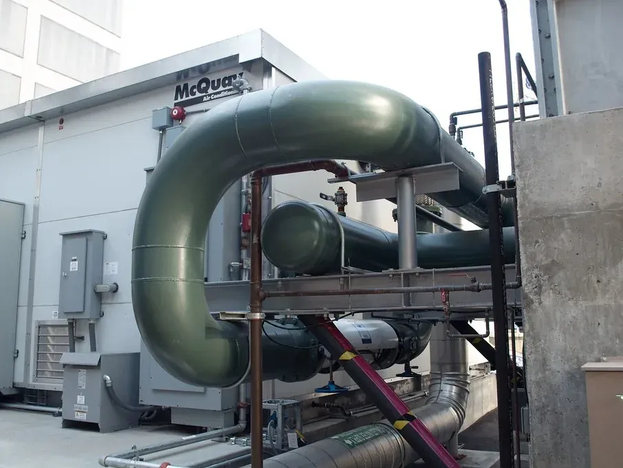 Large rooftop HVAC plant with insulated ductwork on a commercial building